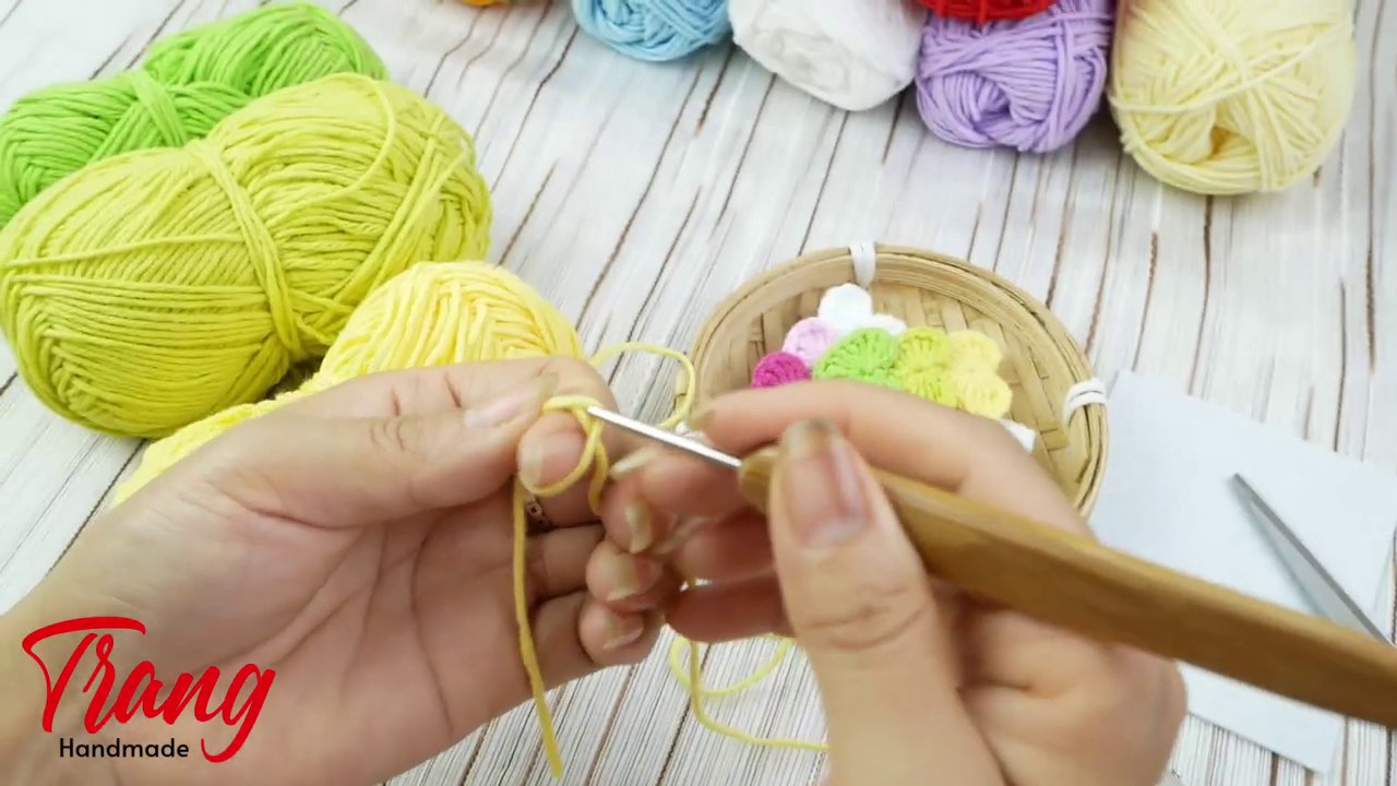 Bộ nguyên liệu gồm len, kim móc, kéo và kẹp tóc được xếp gọn gàng trên bàn.