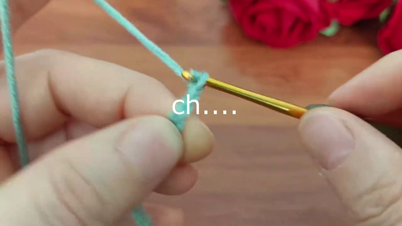 Tay phải điều chỉnh sợi len trên kim trong khi tay trái giữ phần đã móc.