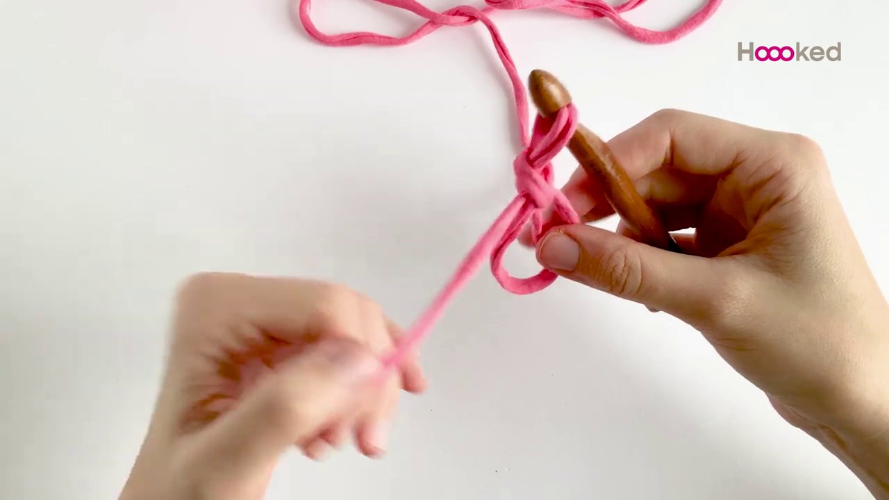 Cuộn len t-shirt spaghetti nhiều màu được đặt cạnh que móc 9mm.