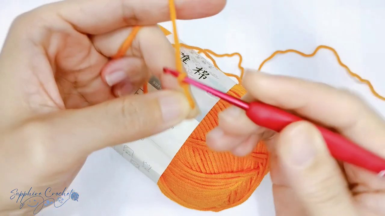 Cận cảnh cách cầm kim và luồn sợi len trong quá trình móc.