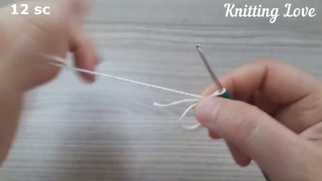 Sợi len xanh được kéo qua kim, chuẩn bị cho các mũi tiếp theo.