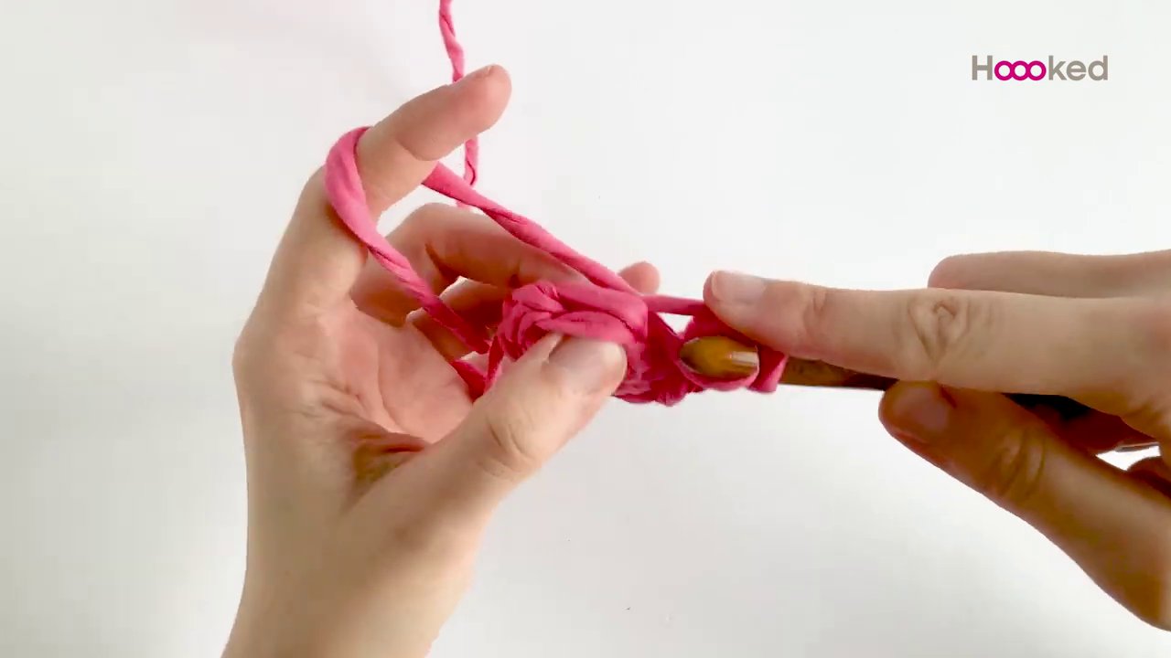 Bàn tay đang luồn que vào vòng sau của một hàng để minh họa kỹ thuật back loop only.
