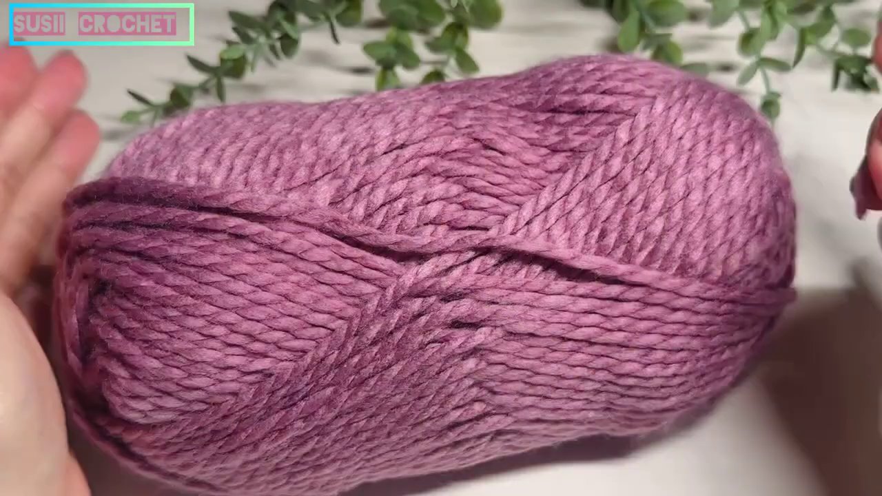 Đôi ta y đang thoăn thoắt móc một chiếc khăn len với những đường mũi đều đặn, thể hiện sự tập trung và kỷ luật.