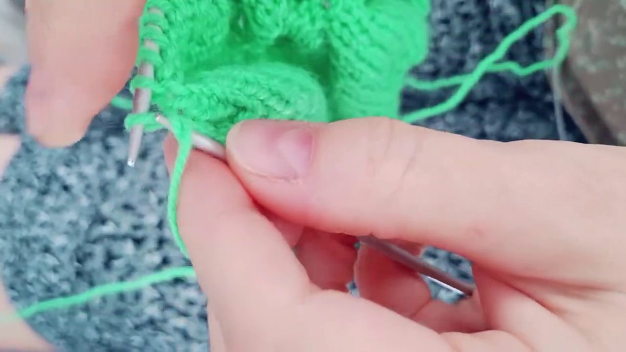 Một người đang móc túi lưới, những mũi móc tạo thành các ô lỗ đều đặn.