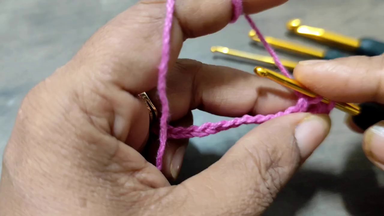 Một mảnh len móc với họa tiết lưới từ mũi kép và mũi xích, màu sắc tươi sáng.